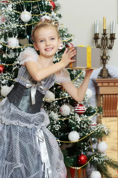 A menina na árvore de Natal gosta dos presentes . — Fotografia de Stock