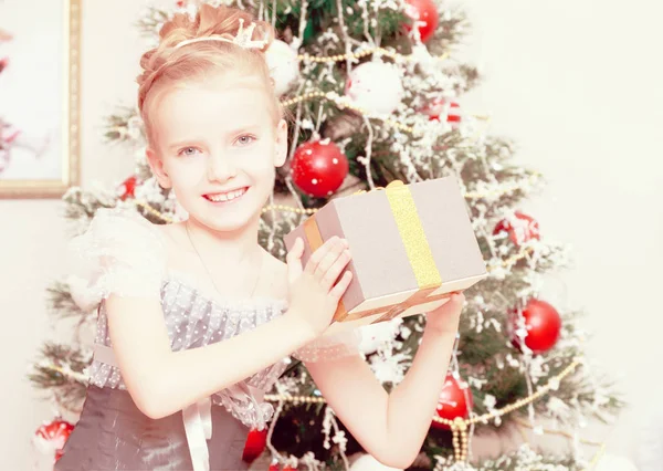 Маленька дівчинка на ялинці насолоджується подарунками . — стокове фото