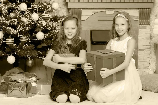 Meninas gêmeas com presentes e árvore de Natal . — Fotografia de Stock