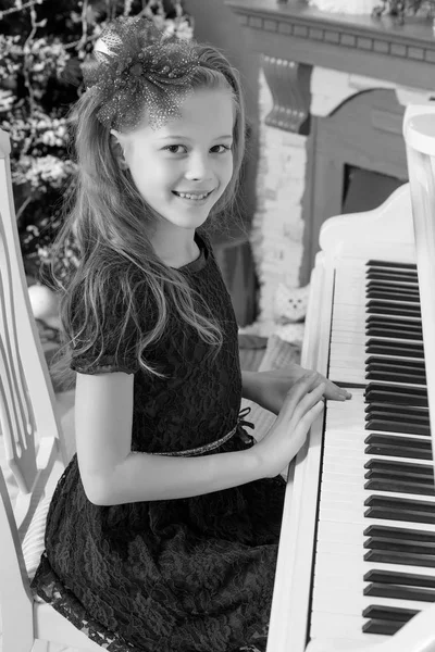 Niña en un piano blanco . —  Fotos de Stock