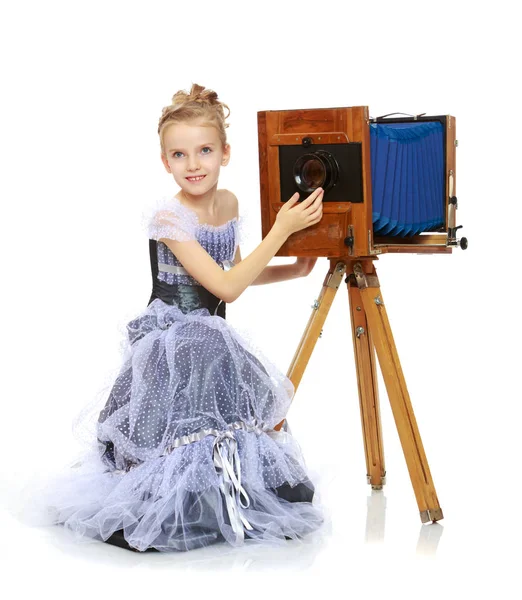Malá dívka pózuje u starý fotoaparát. — Stock fotografie