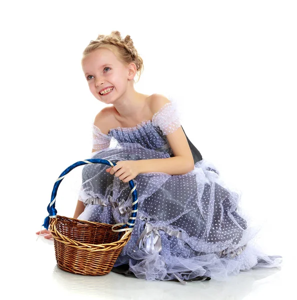 A girl holds a wicker basket. — Stock Photo, Image