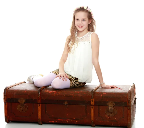 Chica sentada en una vieja maleta . —  Fotos de Stock