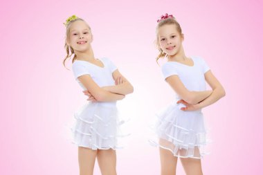 2 kız jimnastikçi beyaz elbiseli.