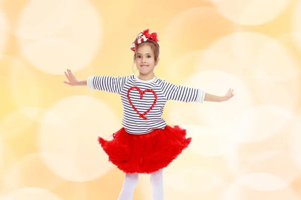 Little girl in a red skirt and bow on her head. — Stock Photo, Image