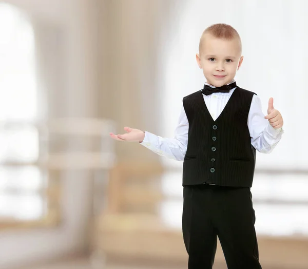 Модный маленький мальчик в черном костюме с галстуком . — стоковое фото