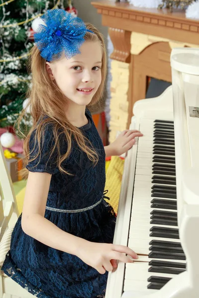 Little girl at a white Grand piano. — Stock Photo, Image