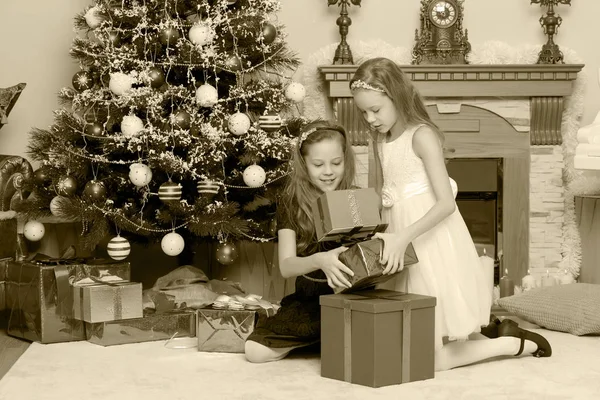Δίδυμα κορίτσια με e δώρα Χριστουγεννιάτικο δέντρο. — Φωτογραφία Αρχείου