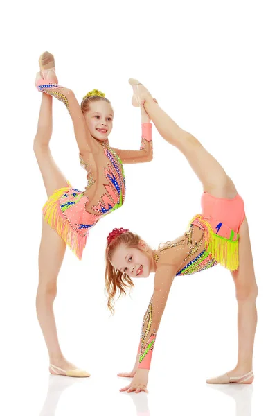 Dvě dívky gymnastka sedí na rozdělení. — Stock fotografie