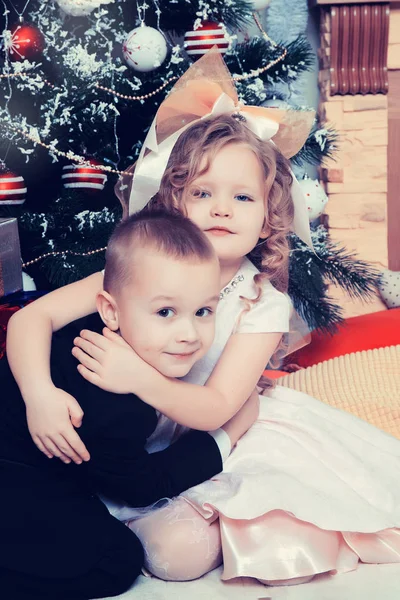 Niño y niña con regalos cerca del árbol de Navidad . —  Fotos de Stock