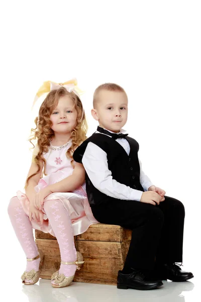 Boys girls sit on old trunk. — Stock Photo, Image