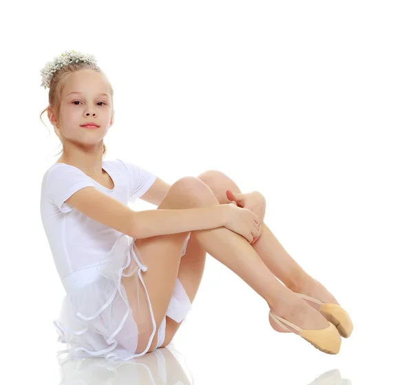Дівчина гімнастка позує, сидячи на підлозі . — стокове фото