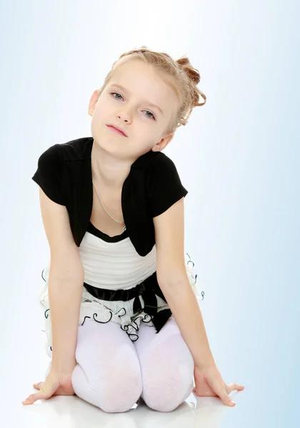 Girl sitting on the floor leaning on hands and smiling at the ca — Stock Photo, Image