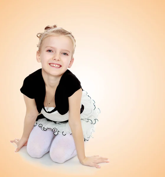 The girl kneeling on the floor smiling directly into the camera. — Stock Photo, Image