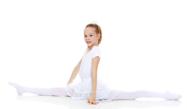 Little girl performs gymnastic exercise, the splits. — Stock Photo, Image