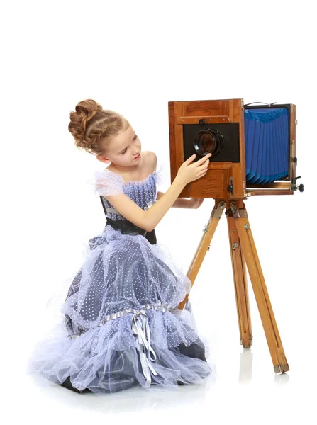 Bambina in posa vicino alla vecchia macchina fotografica . — Foto Stock