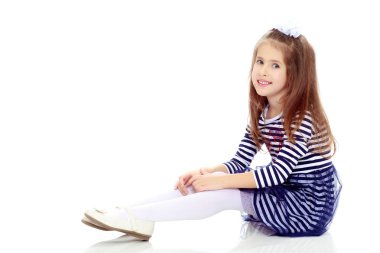 Küçük kız yerde oturuyor..