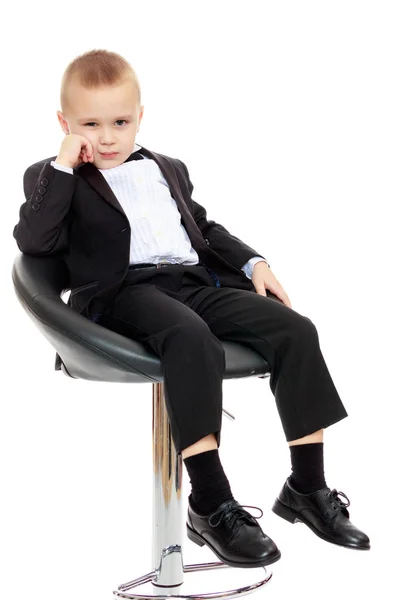 El chico se sienta en una silla giratoria . — Foto de Stock