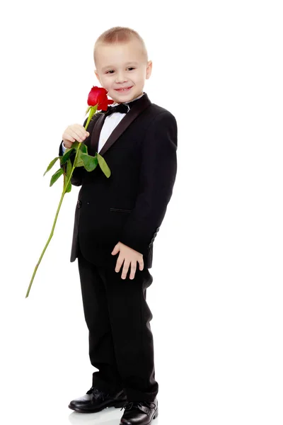 Niño pequeño con una flor de rosa . — Foto de Stock