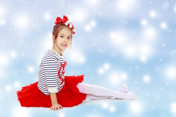 Little girl in a red skirt and bow on her head. — Stock Photo, Image