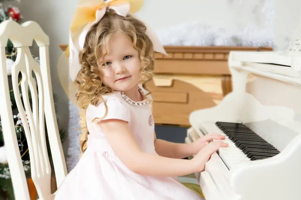 Liten flicka spelar musik på piano. — Stockfoto