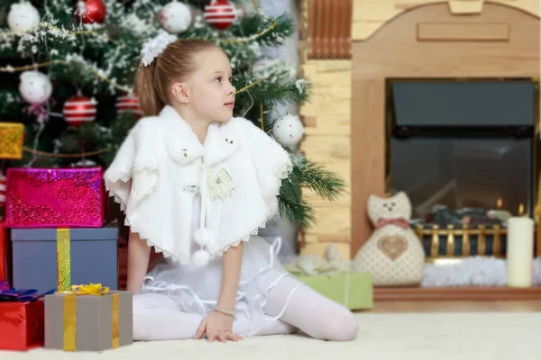 Маленькая девочка с подарками у елки — стоковое фото