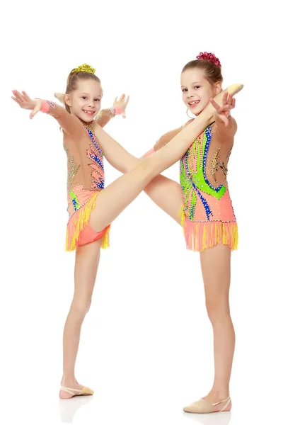 Duas meninas ginasta sentado em divisões . — Fotografia de Stock