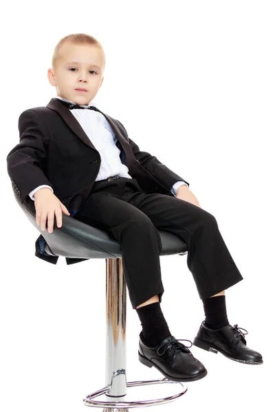 El chico se sienta en una silla giratoria . —  Fotos de Stock