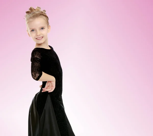 Schöne kleine Tänzerin in einem schwarzen Kleid. — Stockfoto