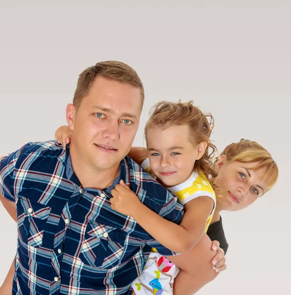 Mom and daughter look out from behind dad — Stock Photo, Image