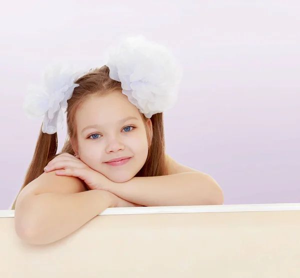 Belle petite fille avec des arcs blancs sur la tête — Photo