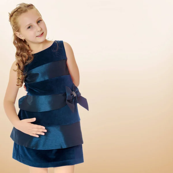 Hermosa niña vestida con un vestido azul . — Foto de Stock