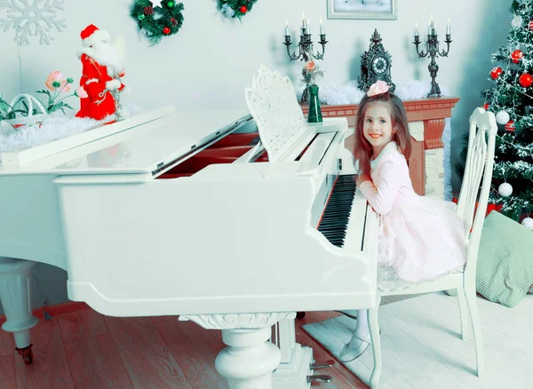 Bambina a un pianoforte a coda bianco . — Foto Stock