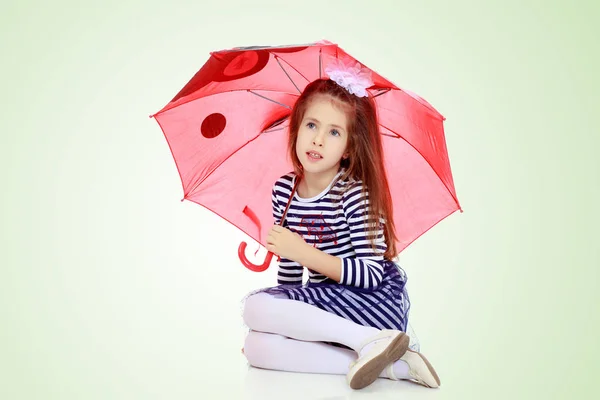 Meisje verstopt onder een paraplu. — Stockfoto