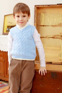 Eski bir sandık içinde küçük bir çocuk duruyor.