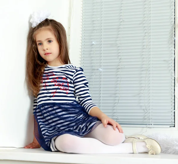 悲伤的小女孩坐在窗边. — 图库照片