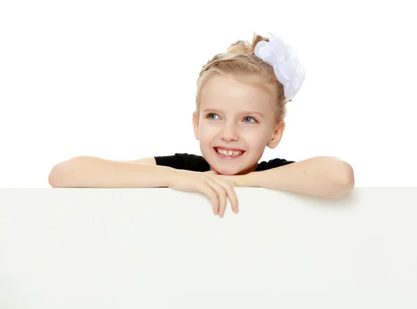 The girl peeks out from behind white banner. — Stock Photo, Image