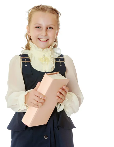 Chica de la escuela en un vestido negro y libro en sus manos . — Foto de Stock