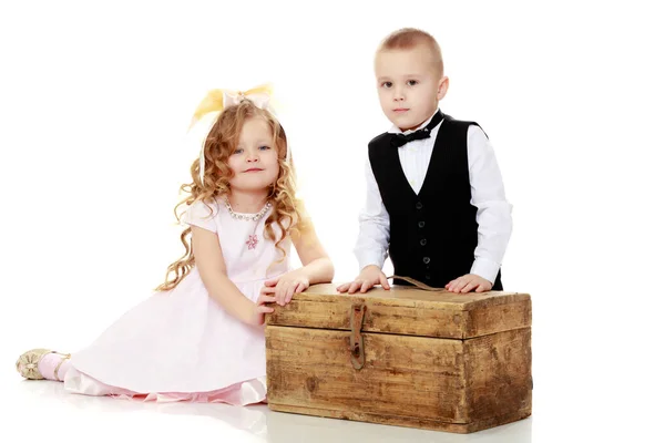 Boys girls sit on old trunk. — Stock Photo, Image