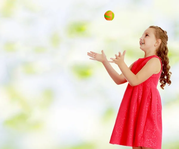 The little girl throws the ball up — Stock Photo, Image
