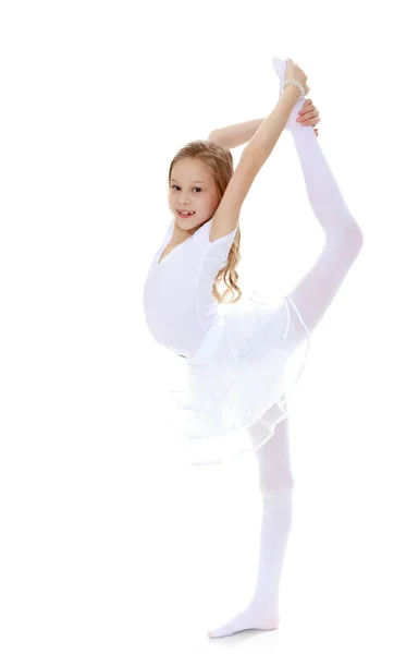 Little gymnast carefully bends your body. — Stock Photo, Image