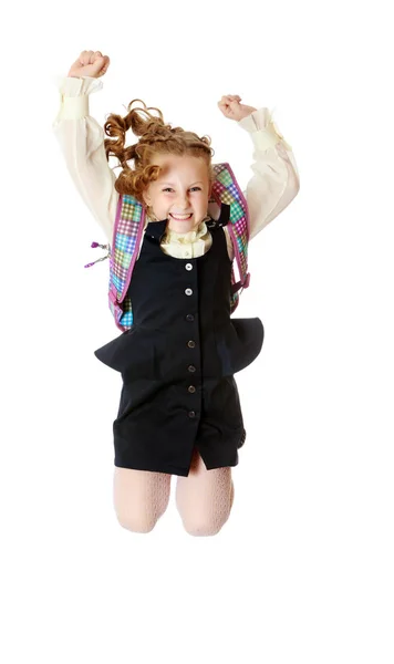 Girl schoolgirl with a satchel behind shoulders jumps — Stock Photo, Image