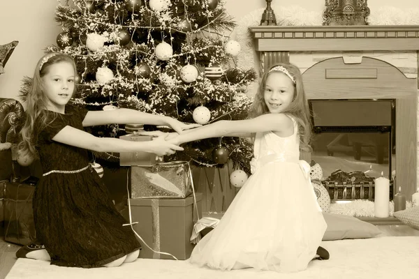 ギフト e クリスマス ツリーと双子の女の子. — ストック写真