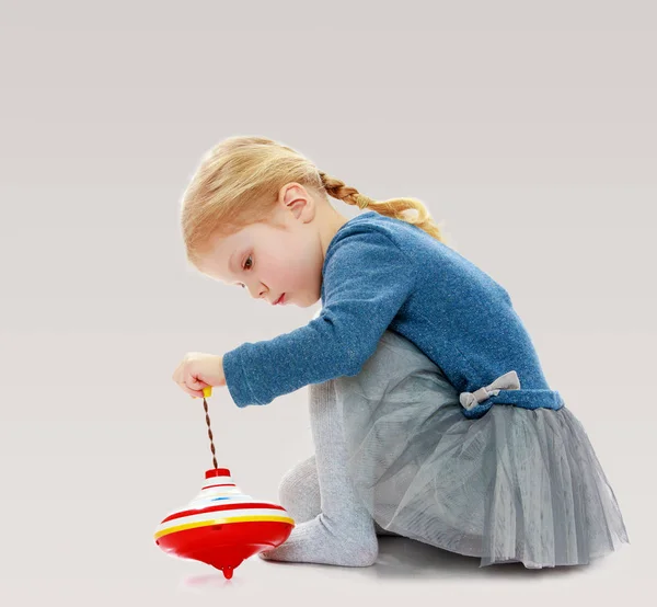 Girl playing humming top. — Stock Photo, Image