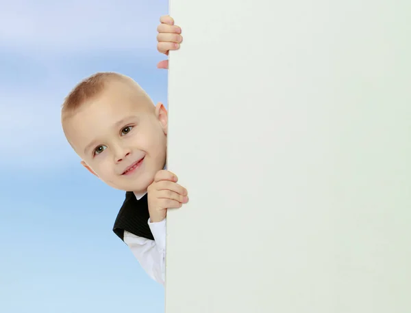 Pojke kikar ut från bakom banderollen — Stockfoto