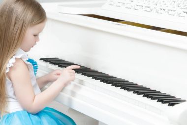 Küçük kız piyano çalıyor.