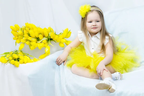 Uma menina com um buquê de tulipas amarelas . — Fotografia de Stock