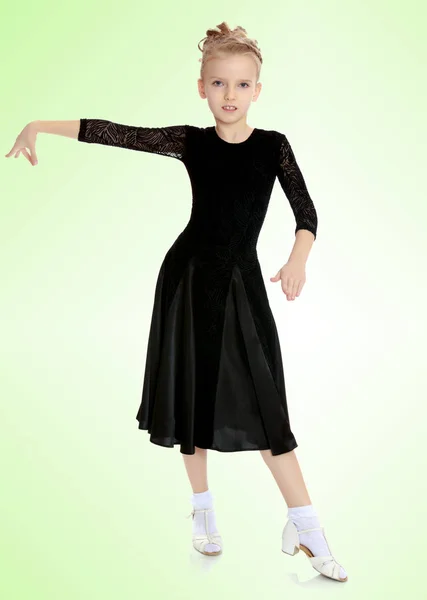 Schöne kleine Tänzerin in einem schwarzen Kleid. — Stockfoto