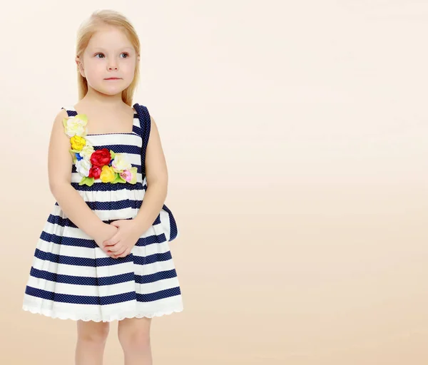 Klein meisje in een gestreepte jurk. — Stockfoto