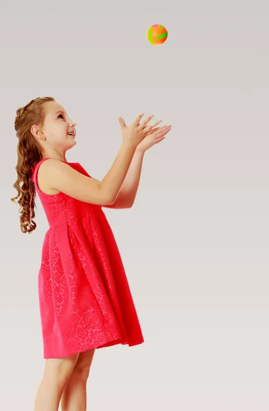 The little girl throws the ball up — Stock Photo, Image